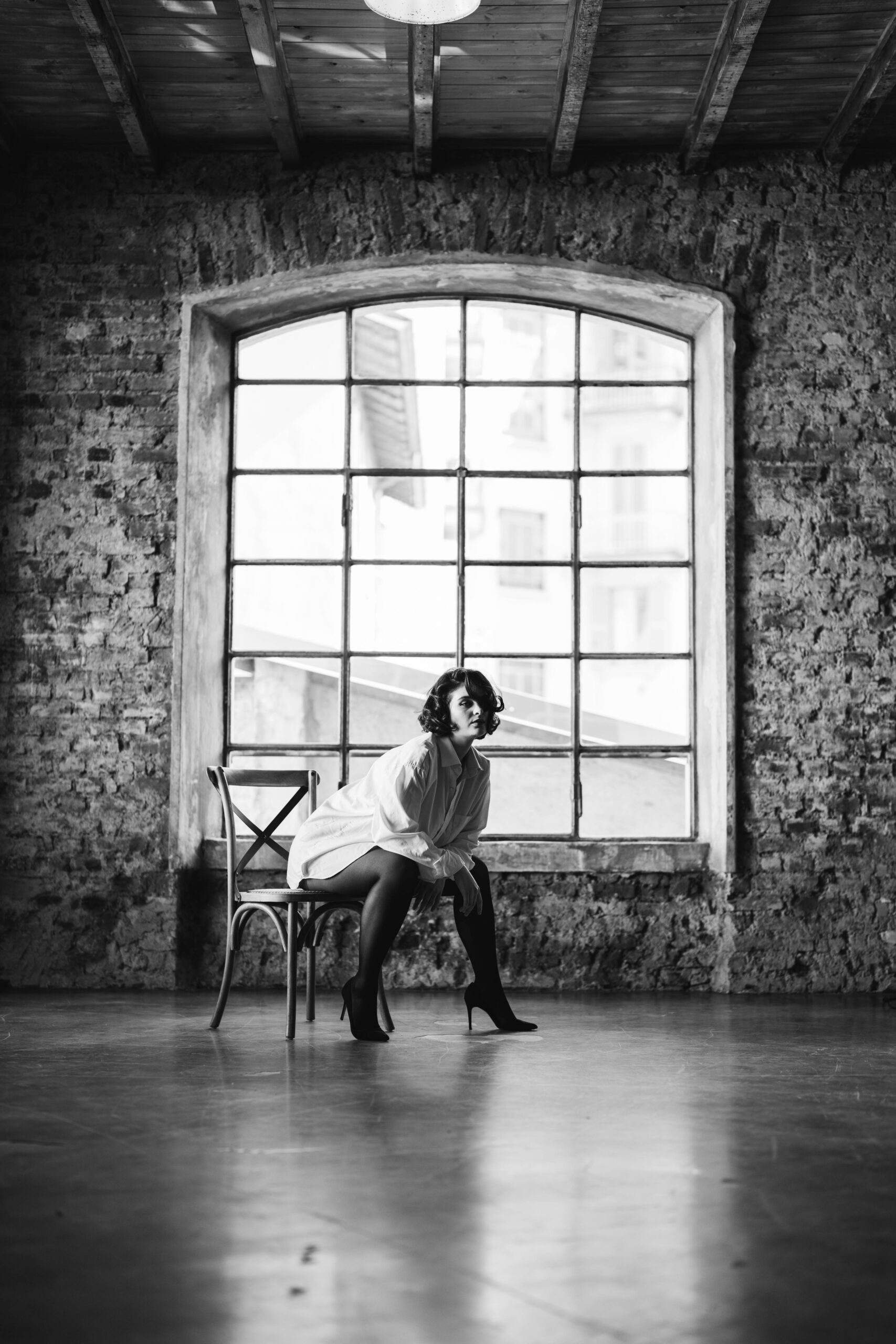 A woman looks away while posing in lingerie for a boudoir shoot.
