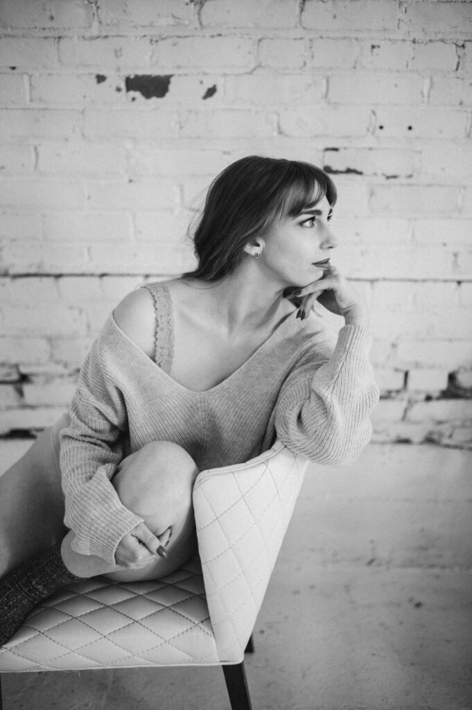 A black and white photo of a woman looking off in the distance during a boudoir session