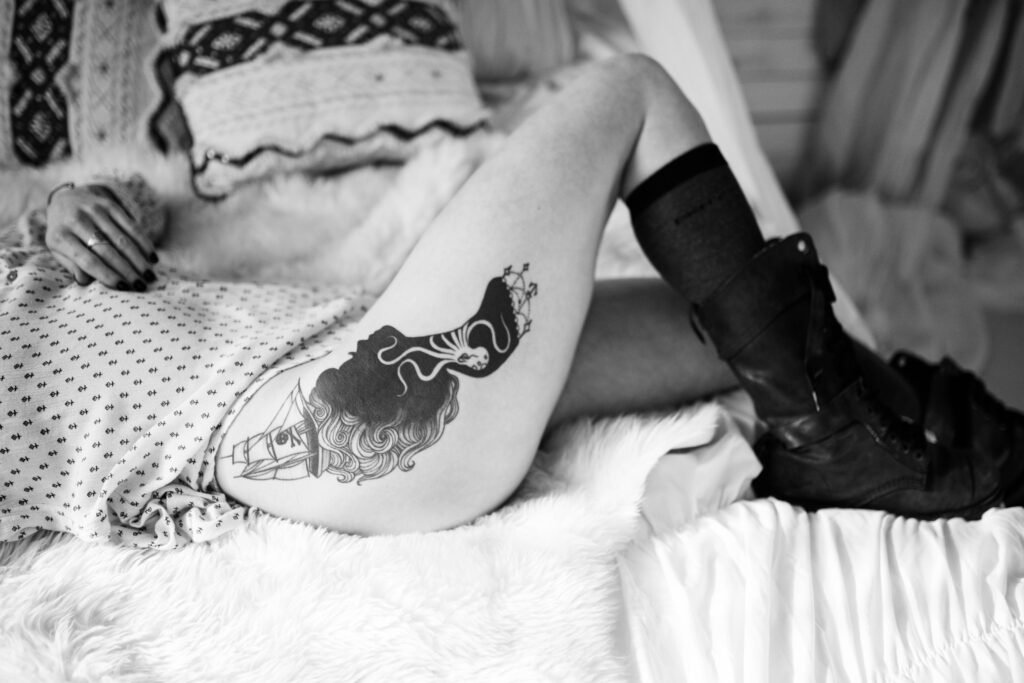 A woman's leg is shown with a tattoo on her thigh