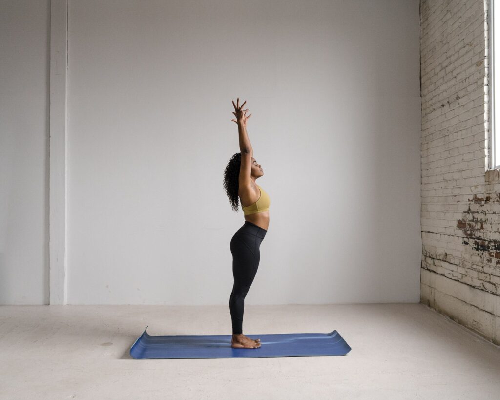 A woman stands in a yoga pose during a boudoir session