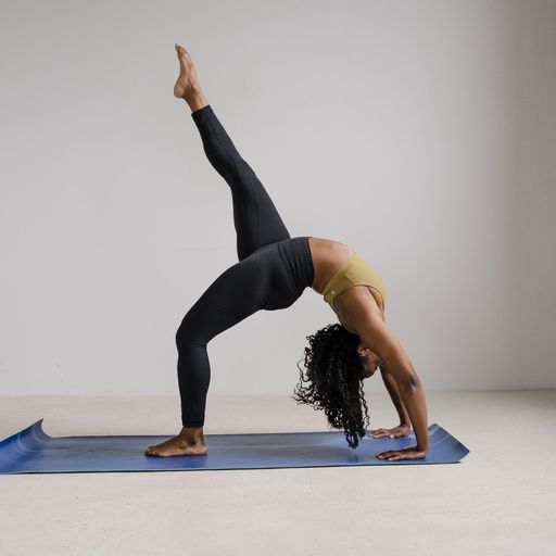 A woman does a yoga pose on a yoga mat in a boudoir studio