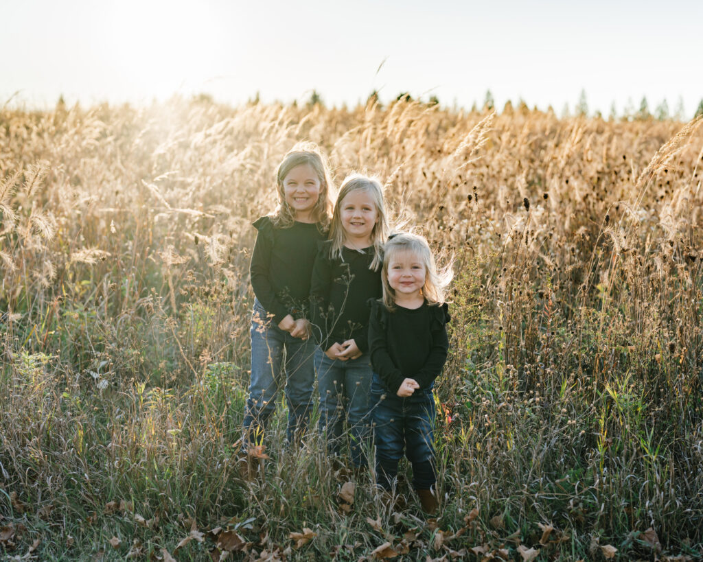 Sisters playing together in autumn leaves, Door County lifestyle family photography
